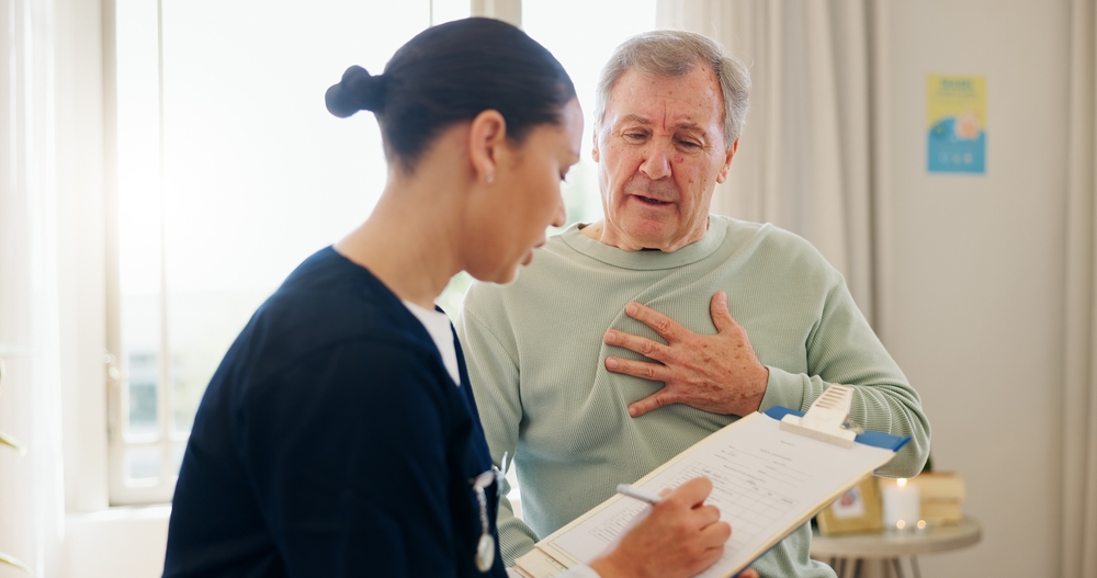 Nurse, clipboard and senior man with heart pain, chest problem or cardiovascular lung fail, tuberculosis risk or cancer. Hypertension, asma and caregiver writing notes, health survey or ask questions
