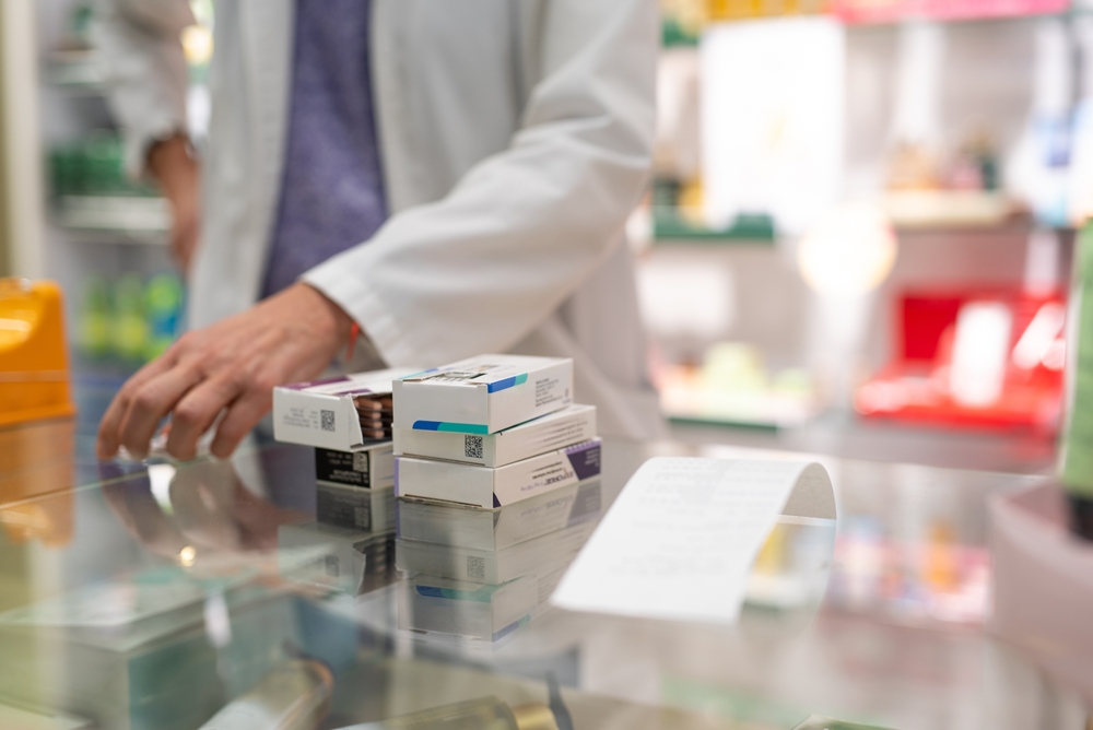 Medications stacked on a pharmacy counter, ready to be sold. Represents a typical scene in the daily routine of a pharmacy