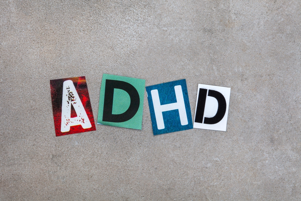 ADHD written in magazine cutout letters on mottled grey
