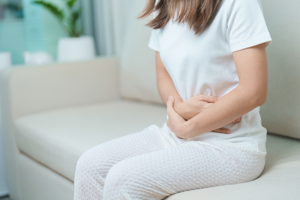 woman having abdomen ache due to Stomach pain, digestion with constipation or Diarrhea from food poisoning, female problem and Endometriosis, Hysterectomy, Stomachache and Menstrual on sofa at home