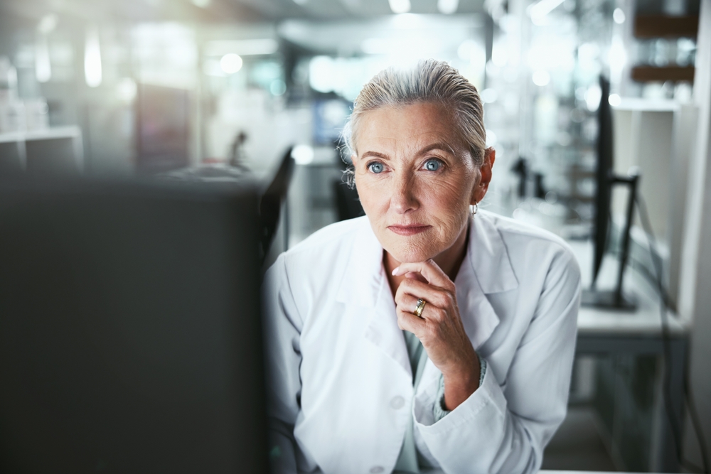 Thinking, woman and scientist by computer in laboratory for medical research on cancer drug trial. Ideas, project and mature female biologist with clinic protocol development for pharmaceutical study
