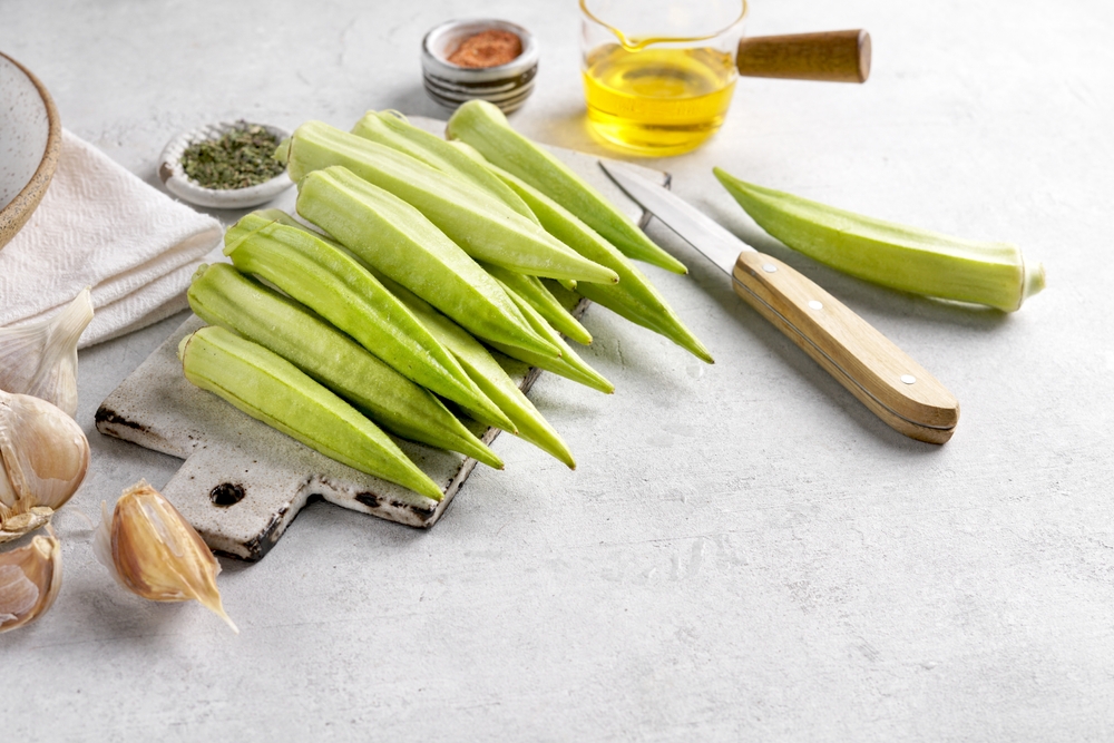 Bamya or okra on cutting board, fresh Egyptian okra ready for cooking on gray background, copy space
