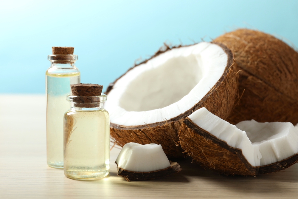 Bottle of coconut oil on wooden background