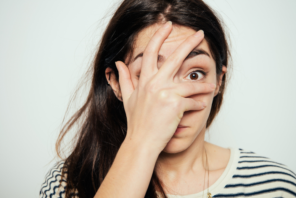 Woman covers his face by hand
