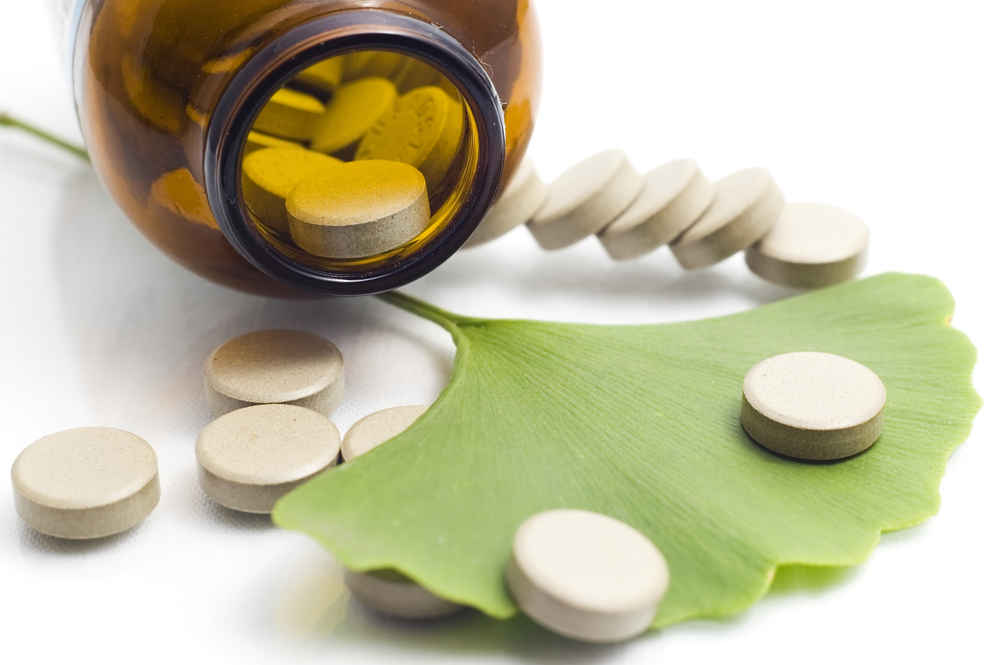 Closeup of Ginkgo Biloba extract pills and fresh Ginkgo Biloba leaves best suited for aged people alternative medicine ads
