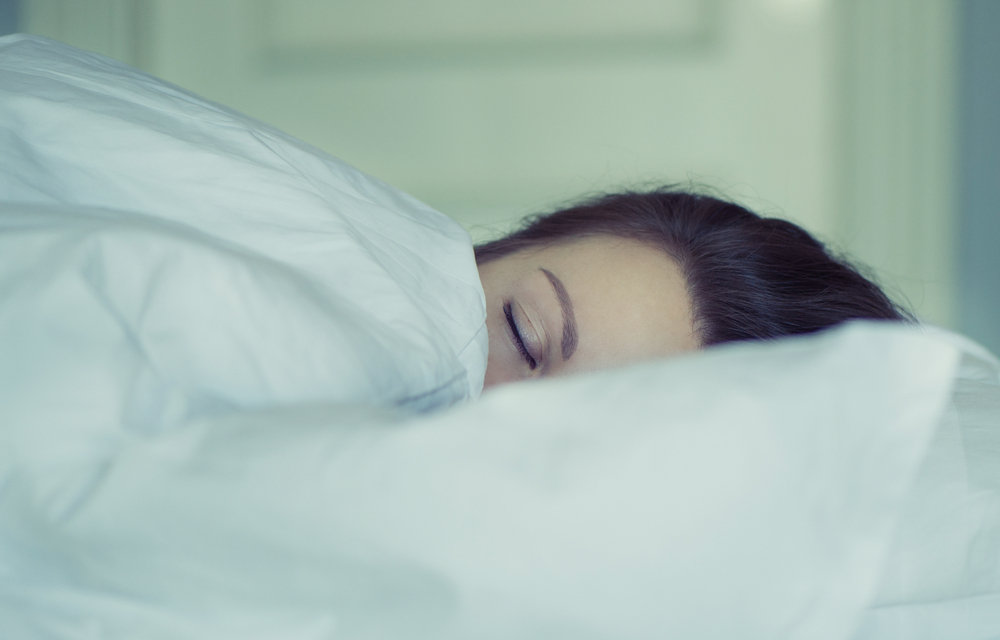 A girl lies in bed can't fall asleep thinking and dreaming. Insomnia. Psychology.
