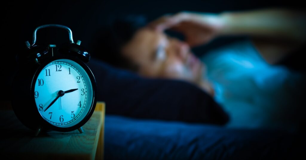 asian man in bed suffering insomnia and sleep disorder thinking about his problem at night