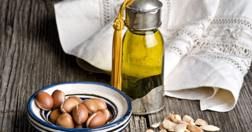 Bottle of argan oil and argan fruit. Argan oil is used for skincare products.