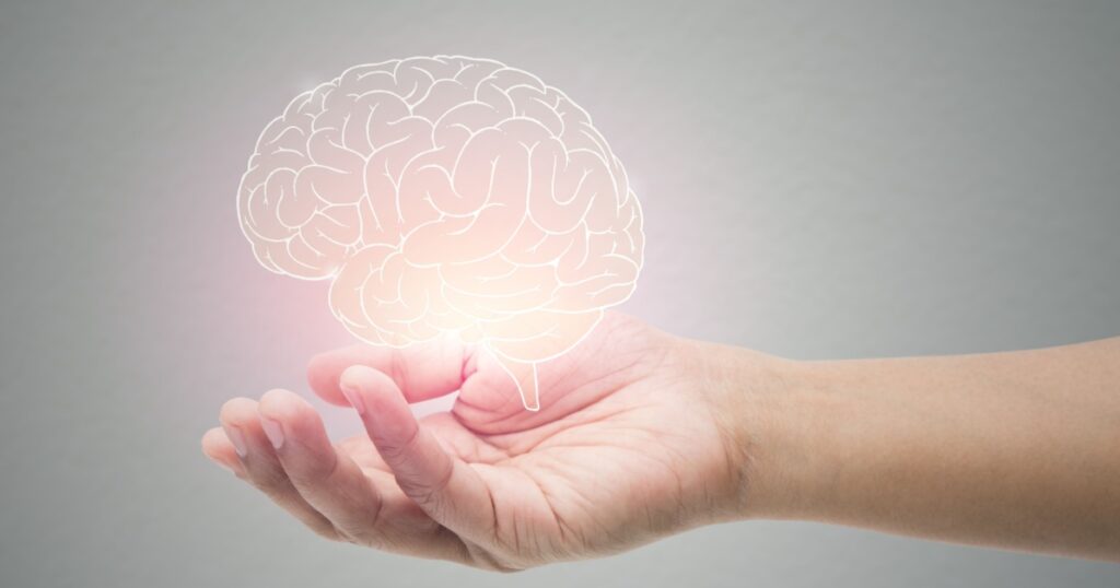 Man holding brain illustration against gray wall background. Concept with mental health protection and care.