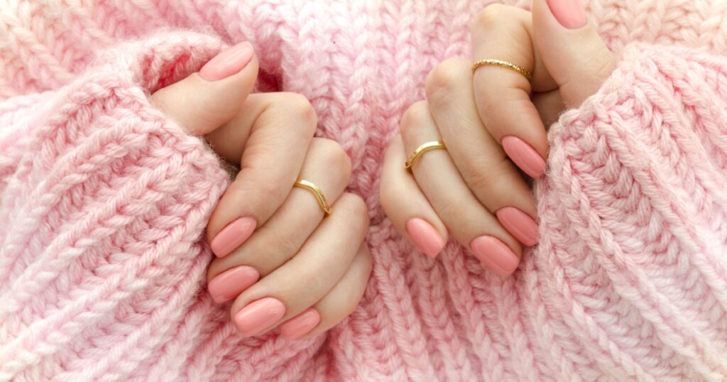 Nail Polish. Art Manicure. Modern style pink Nail Polish.Stylish pastel Color pink Nails holding wool material sleeve blouse . Classic wedding bride nails design