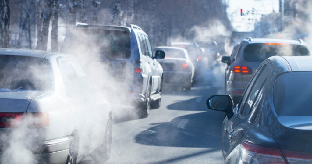 pollution from the exhaust of cars in the city in the winter. Smoke from cars on a cold winter day