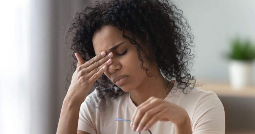 Tired stressed overworked young african woman student feel hurt fatigue eye strain headache after computer work take off glasses suffer from pain in dry eyes, bad vision problem, eyestrain concept