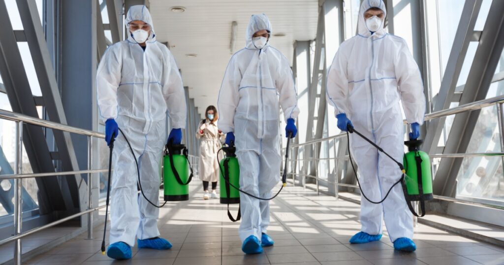Specialist in hazmat suits cleaning disinfecting coronavirus cells epidemic, pandemic health risk
