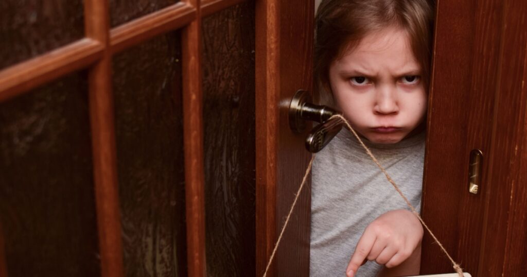 Unique child. An angry child closes the door to his room and points to a sign that says No entry. The child does not let her parents into the room. Upbringing problems, Conquering personal space