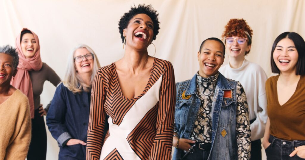 International Women's Day portrait of cheerful multi ethnic mixed age range women laughing and smiling