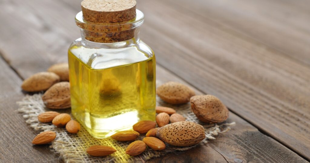 Almond oil in bottle on wooden background
