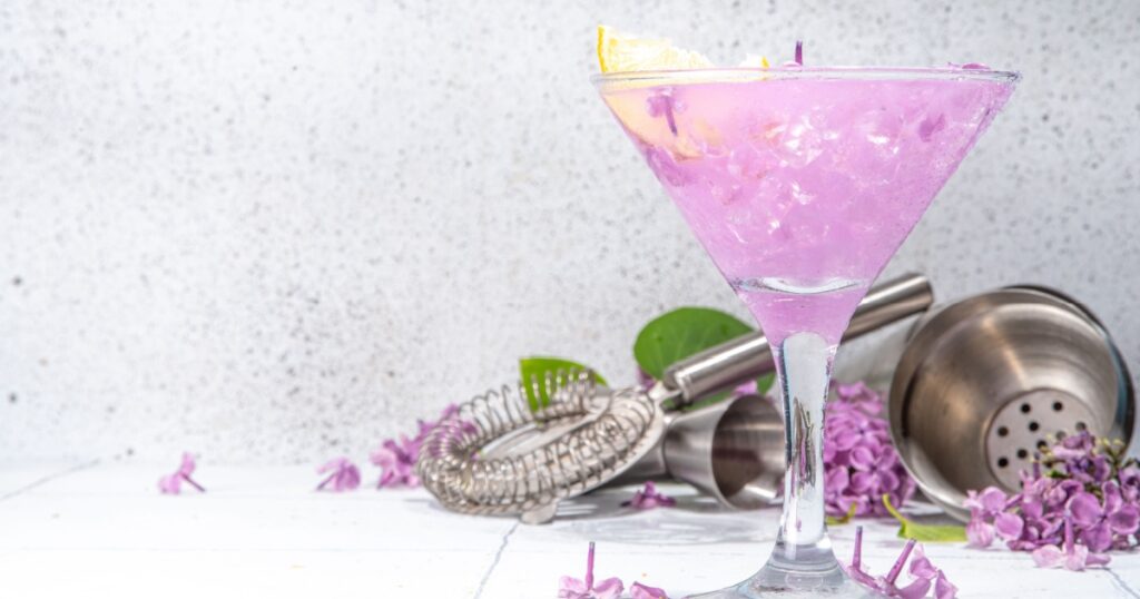 Lilac drink. Alternative organic natural daikiri cocktail or mocktail, infused drink from lilac flowers. Lilac lemonade with ice in margarita cocktail glass