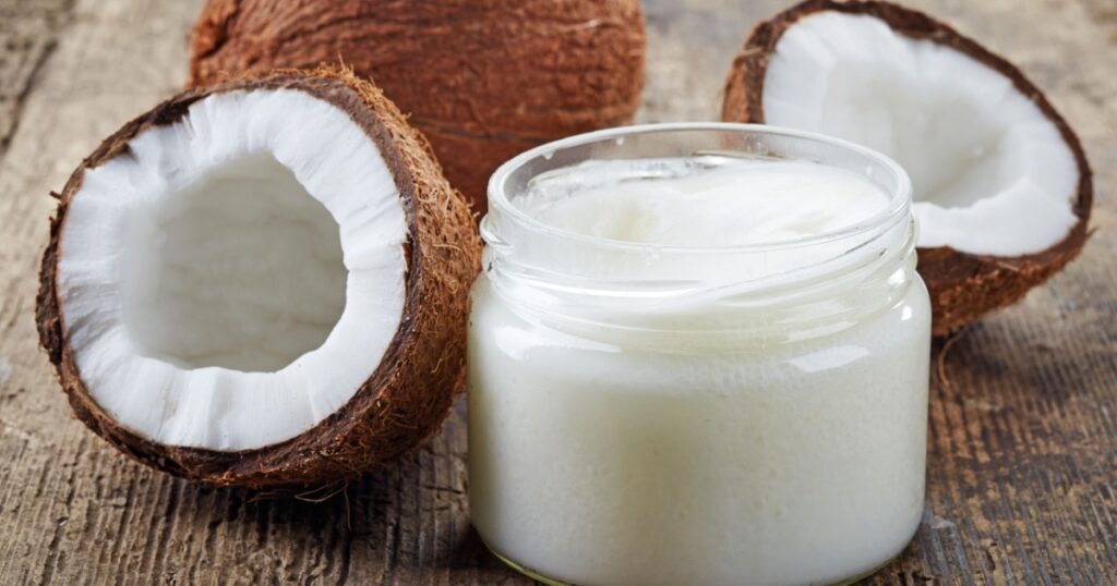 coconut oil and fresh coconuts on old wooden table