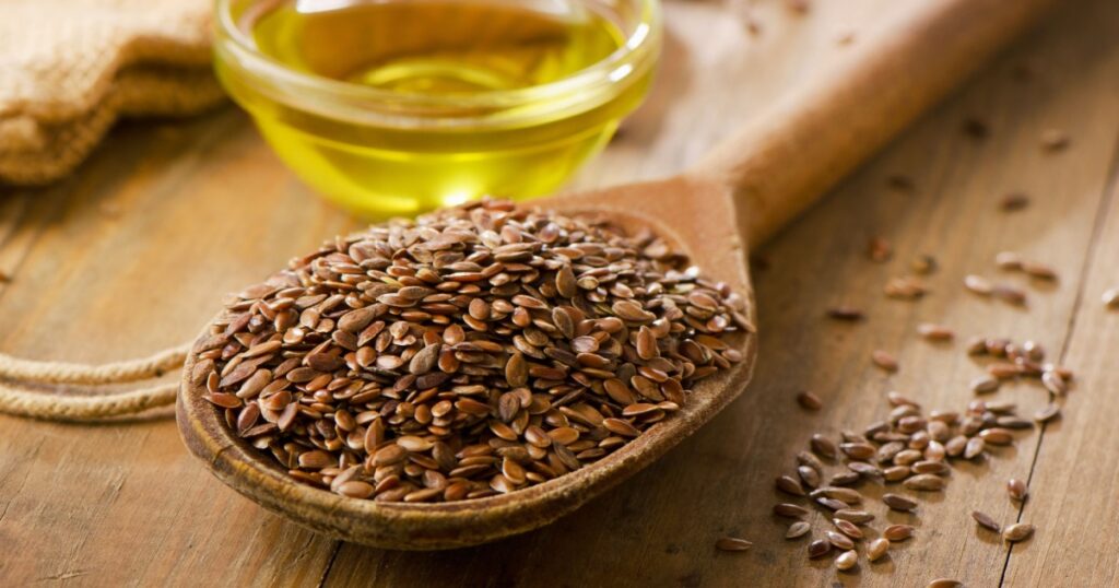 Brown flax seeds on a spoon and flaxseed oil.