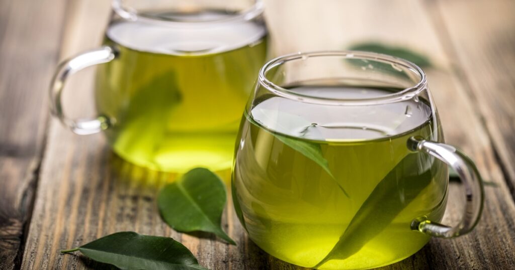Fresh green tea with tea leaves in the water
