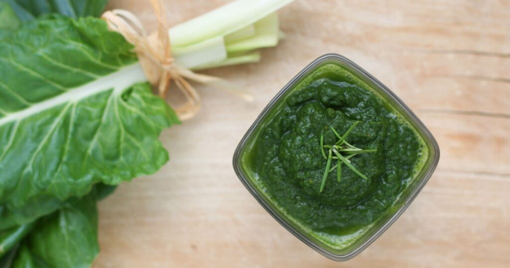 Fresh chard puree or smoothie, freshly picked green swiss chard (Beta vulgaris) leaves as background