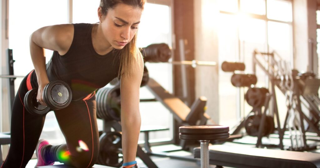 Fitness girl lifting dumbbell in the morning.