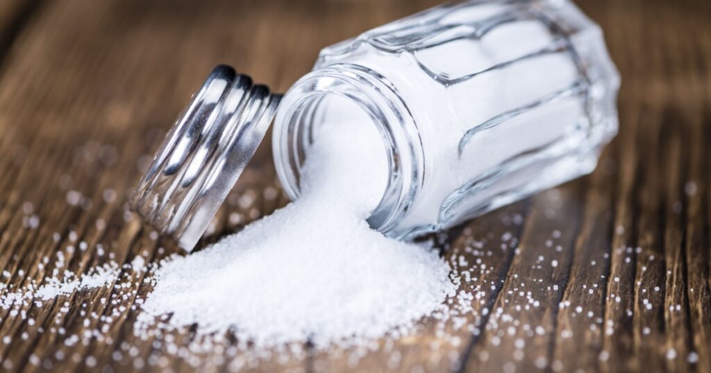 Salt Shaker (close-up shot; selective focus) on vintage wooden background