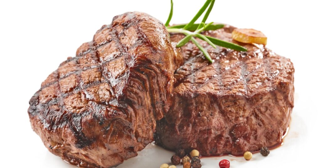 grilled beef steaks with spices isolated on white background