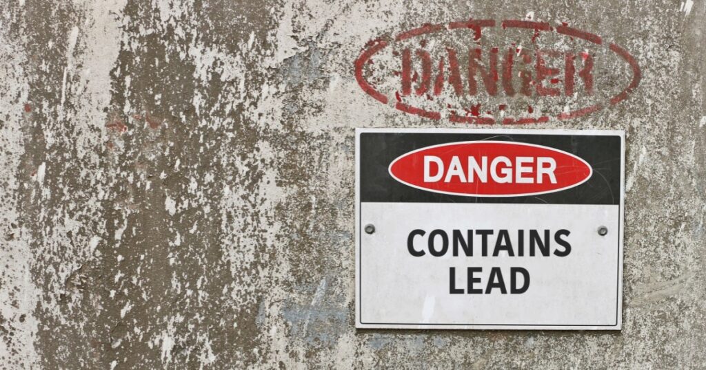red, black and white Danger, Contains Lead warning sign