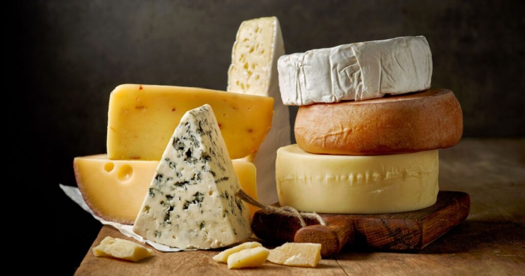 various types of cheese on rustic wooden table