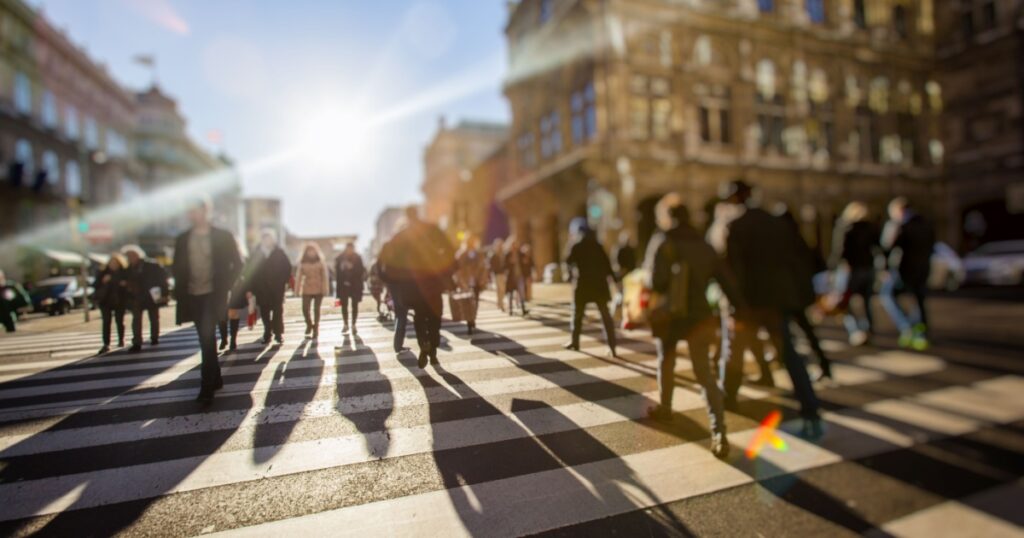 Crowd of anonymous people walking on busy city street