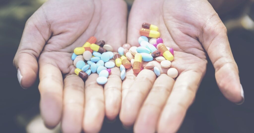 Many pills in hand. Stressed annoyed people suffer from hormone problem.Gradual process of Menopause exhaustion dehydration heatstroke concept.