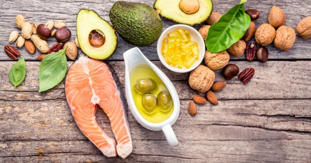 Selection food sources of omega 3 and unsaturated fats. Superfood high vitamin e and dietary fiber for healthy food. Almond,pecan,hazelnuts,walnuts,olive oil,fish oil and salmon on wooden background.