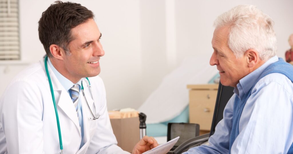 American doctor talking to senior man in surgery