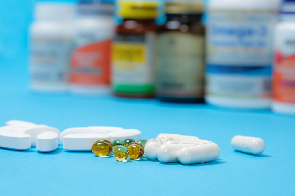 Medicines or dietary supplements on a blue background and jars with pills on the background.
