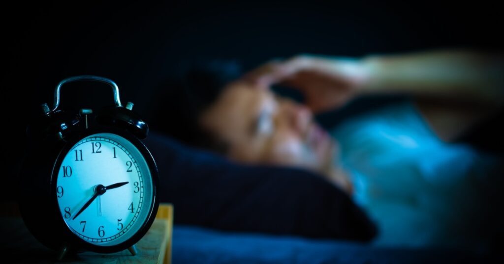 asian man in bed suffering insomnia and sleep disorder thinking about his problem at night