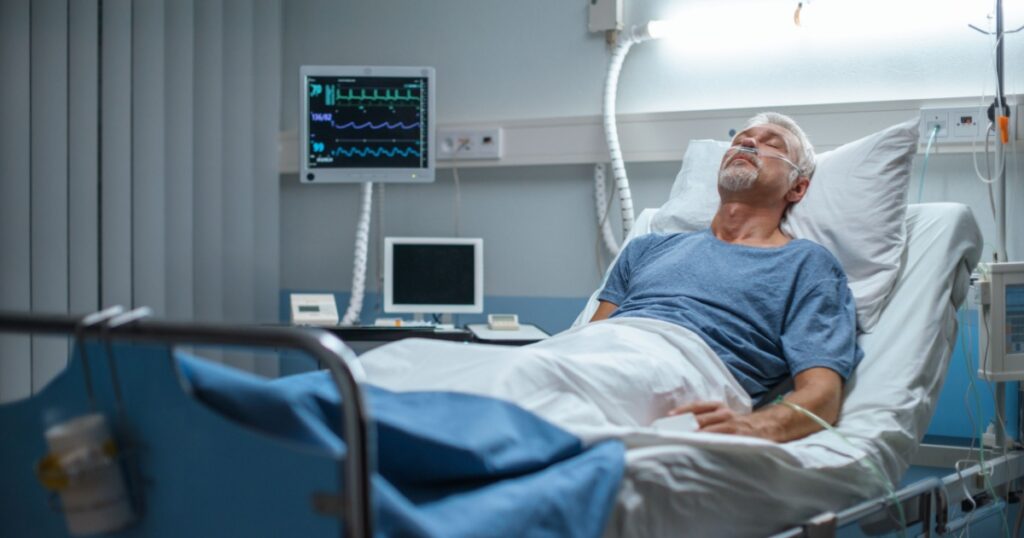 In the Hospital Senior Patient Rests, Lying on the Bed. Recovering Man Sleeping in the Modern Hospital Ward.