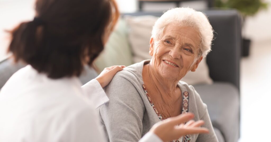 Young doctor visiting elderly woman at home