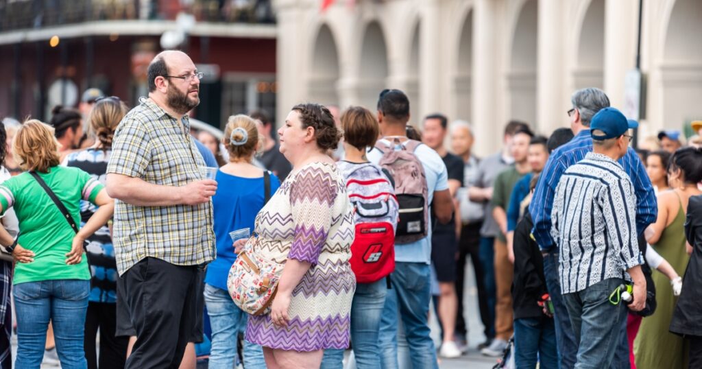 New Orleans, USA - April 22, 2018: Old town chartres street in Louisiana famous town city with many people crowd on Jackson square drinking alcohol from plastic cups
