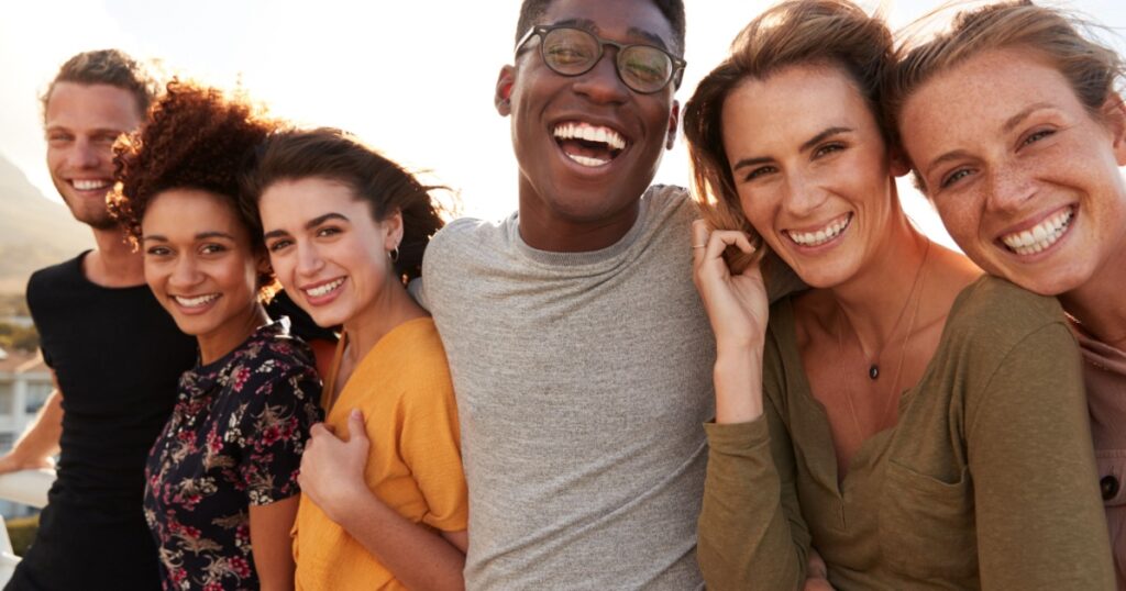 Portrait Of Smiling Young Friends Walking Outdoors Together