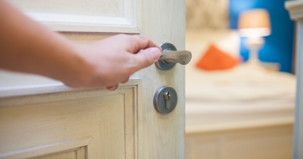 half-open door of a bedroom with hand
