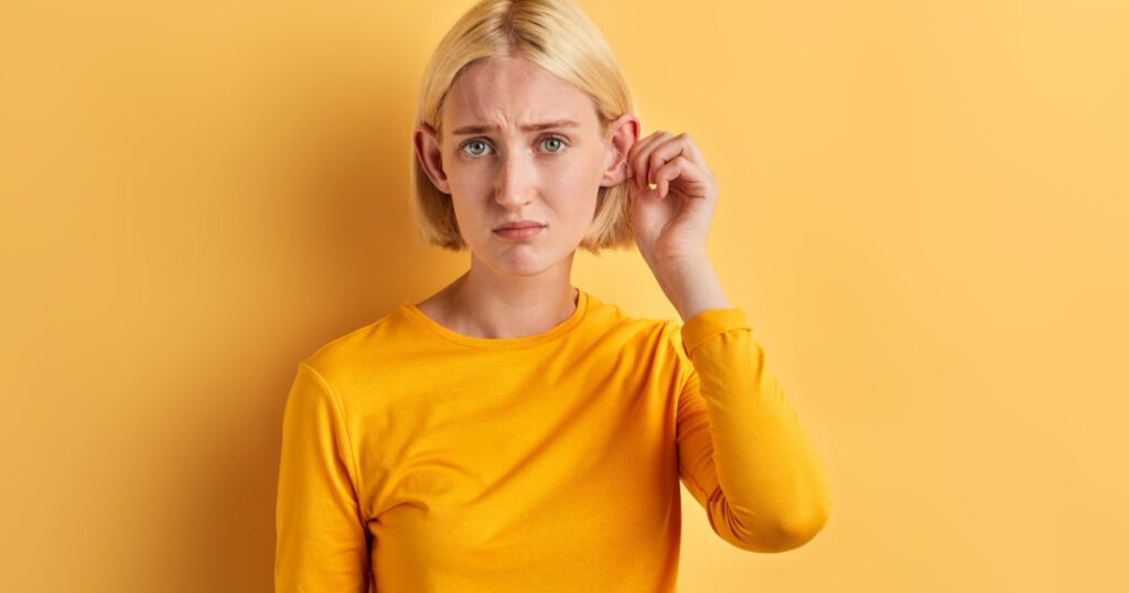 unhappy depressed woman doesn't like her big ears, close up photo. appearance concept,girl has problem with hearing