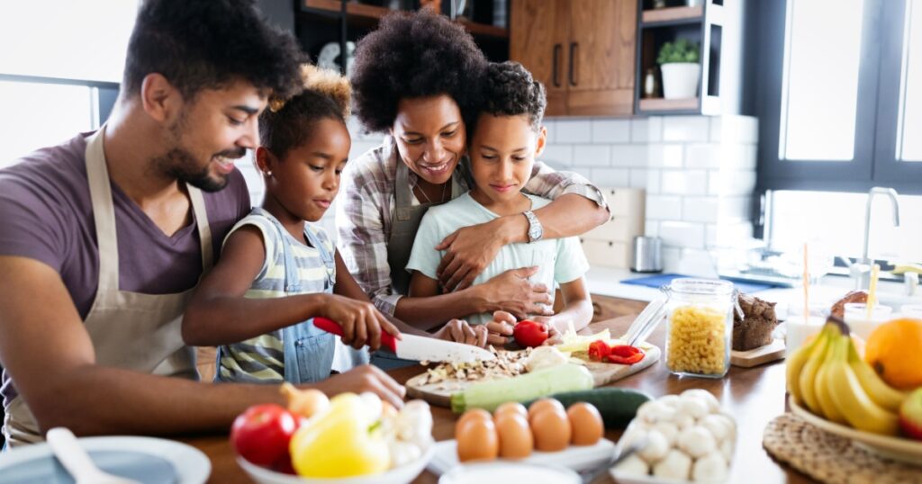 Happy family in the kitchen having fun and cooking together. Healthy food at home.