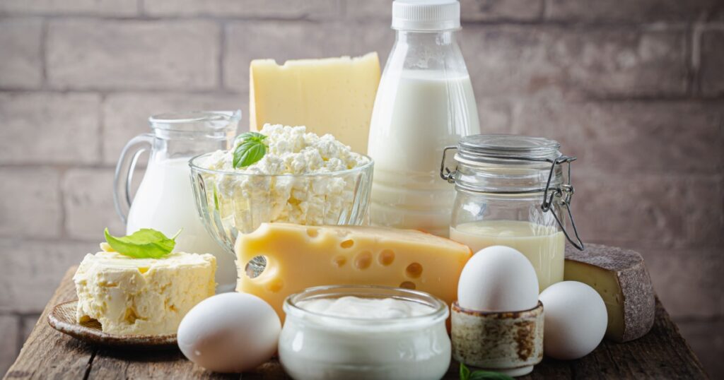 Fresh dairy products, milk, cottage cheese, eggs, yogurt, sour cream and butter on wooden table