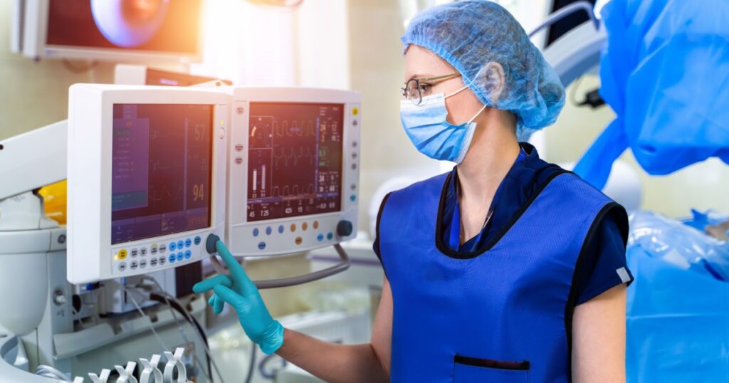 Nurse near the screen of mechanical ventilation equipment. Hospital, surgical operating room. Life saving. Ventilation of the lungs with oxygen. Pneumonia diagnosting. COVID-19