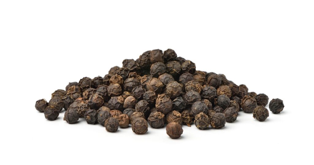 Pile of Black peppercorns (Black pepper) seeds isolated on white background.