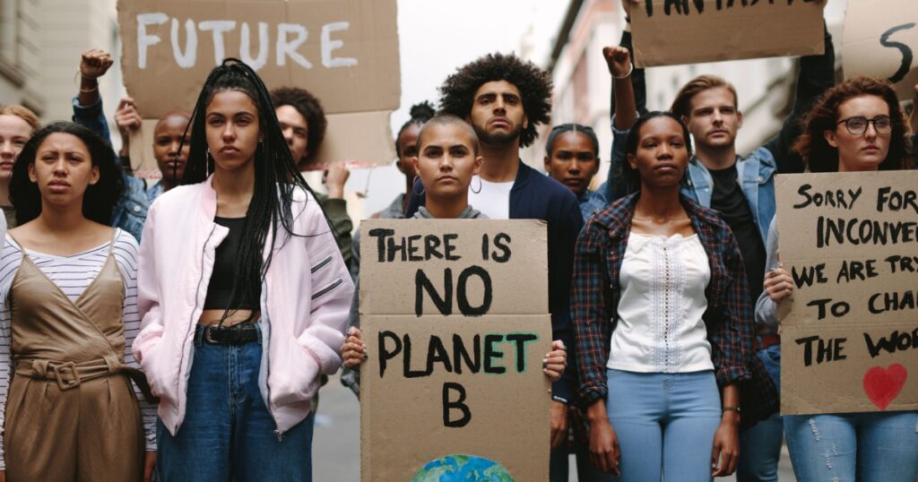 Group of activists with banners protesting to save earth. Men and women rebellions doing a silent protest over global warming and pollution.
