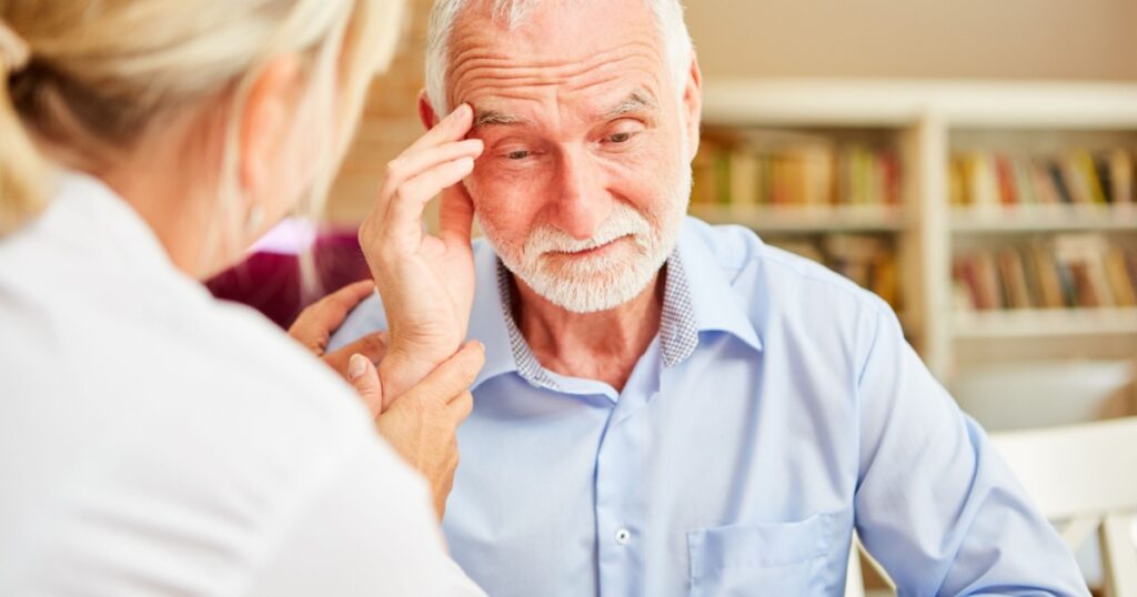 Senior with dementia or Alzheimer's is comforted by caring female doctor