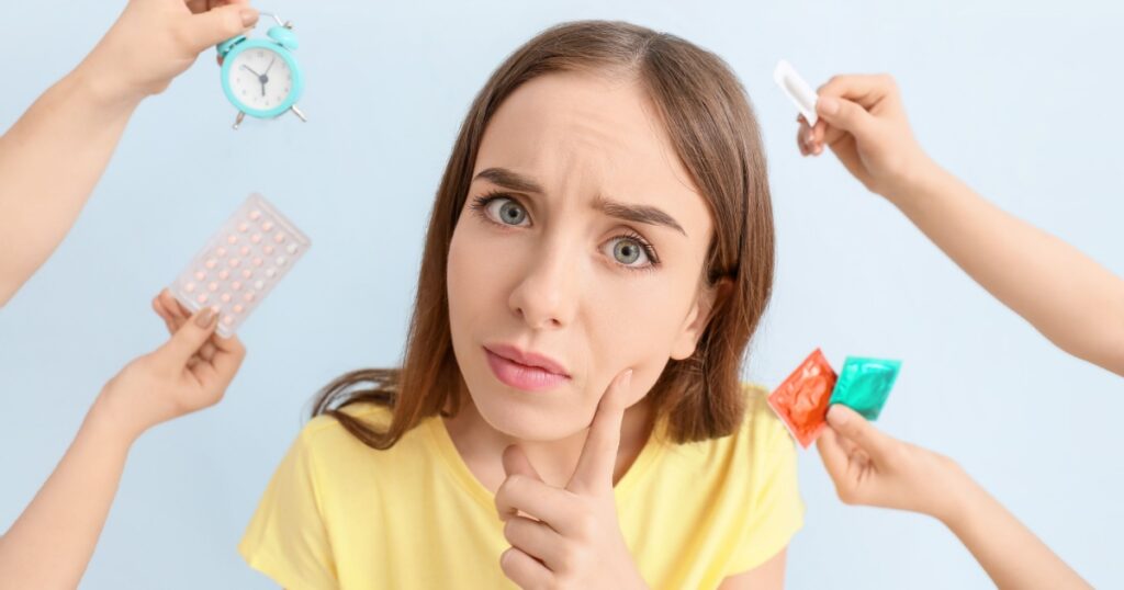 Thoughtful young woman and hands with different means of contraception on color background