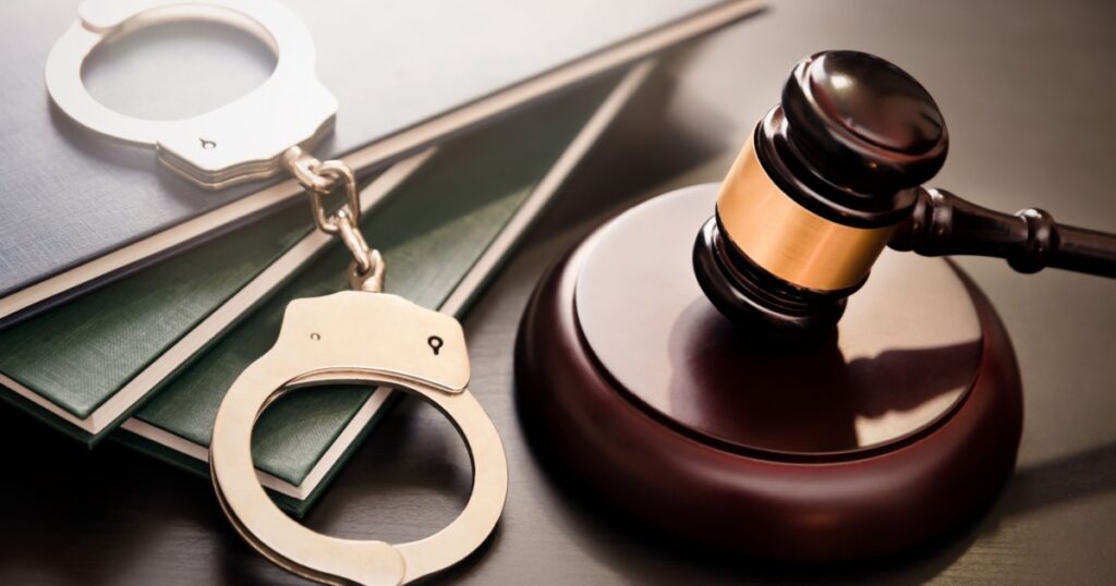 Handcuffs and wooden gavel. Crime and violence concept.
